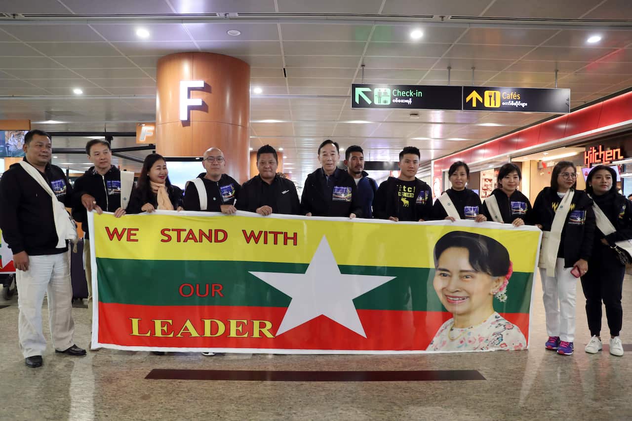 Supporters pose for photos with portrait of Myanmar leader Aung San Suu Kyi before their departure to The Netherlands.