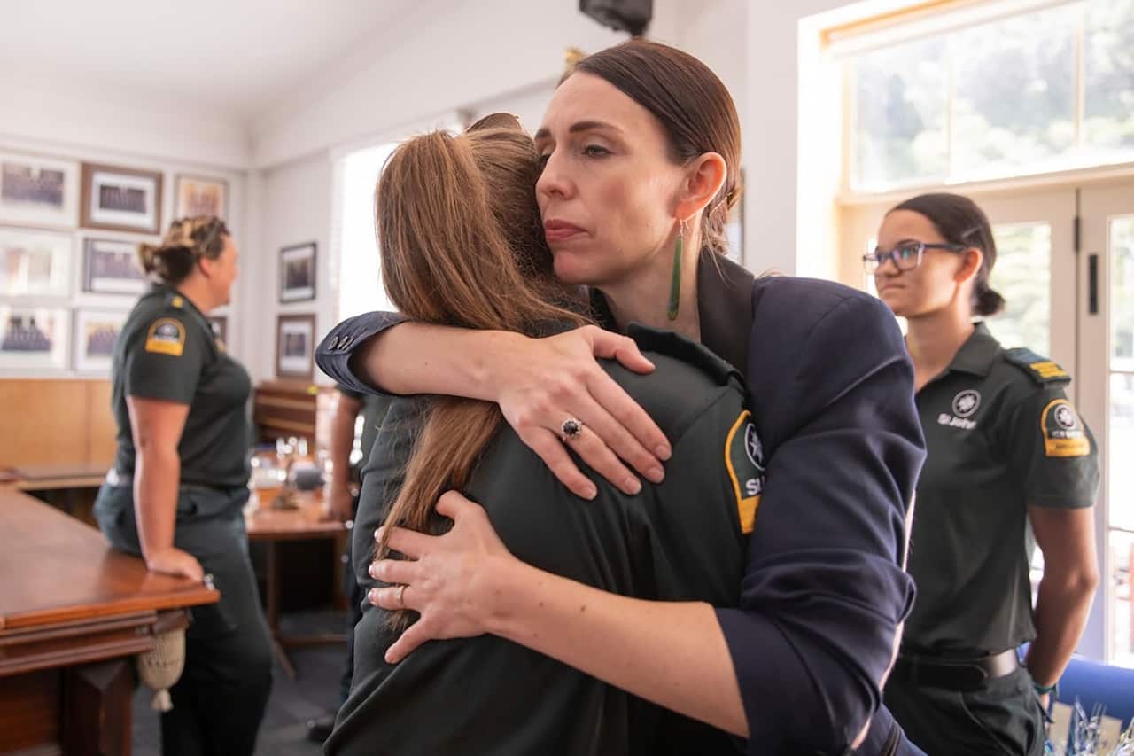 New Zealand's Prime Minister Jacinda Ardern, right, hugs a first responder in Whakatane, New Zealand.