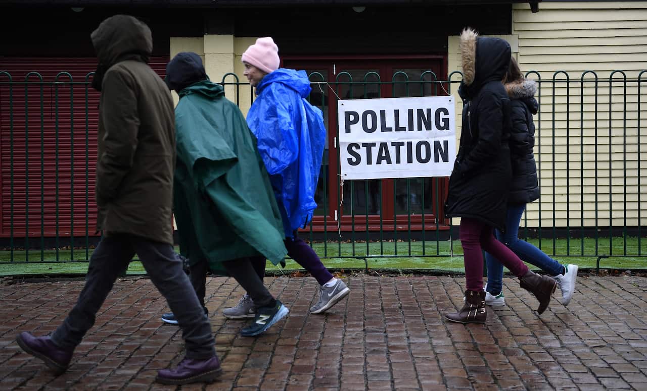 Pedestrians pass a polling station in south London, Britain, 12 December 2019.