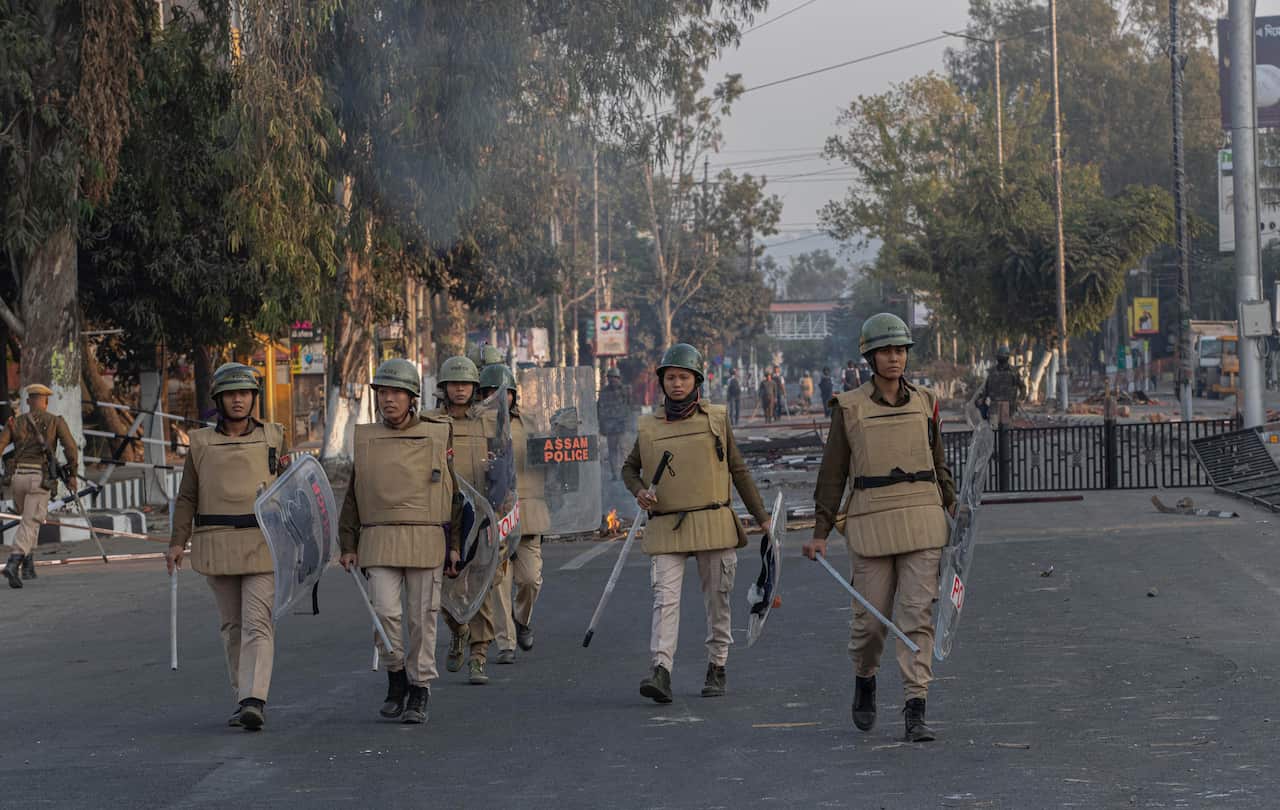 Assam police women patrol during a curfew in Gauhati, India.
