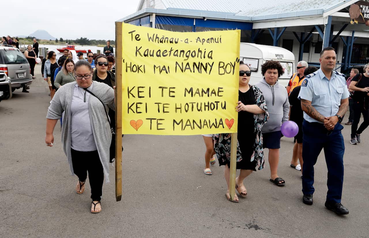 Families of victims of the White Island eruption walk to a nearby marae after arriving back to the Whakatane wharf following a blessing at sea.