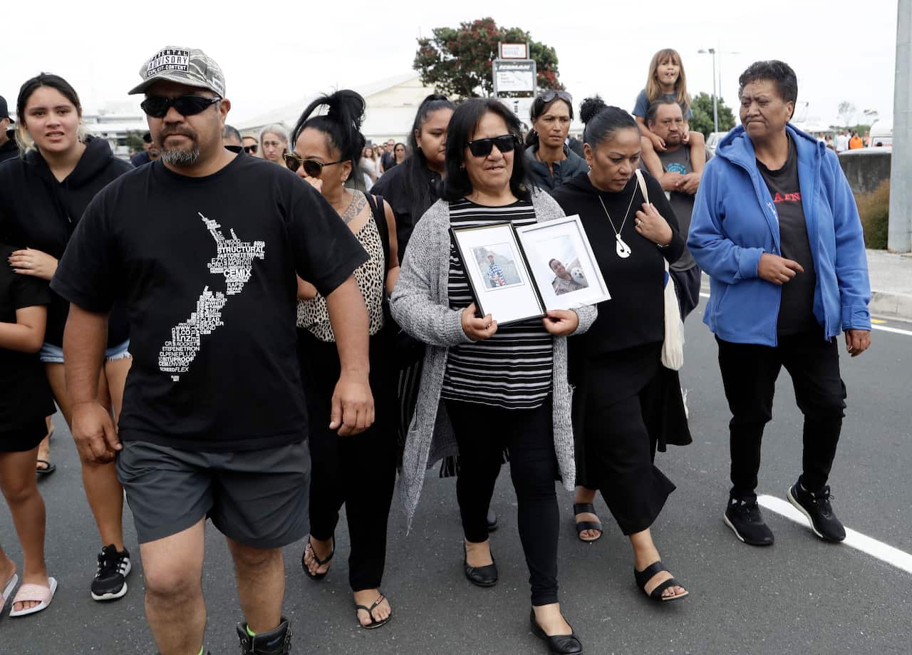 Families of victims of the White Island eruption walk to a nearby marae after arriving back to the Whakatane wharf following a blessing at sea.