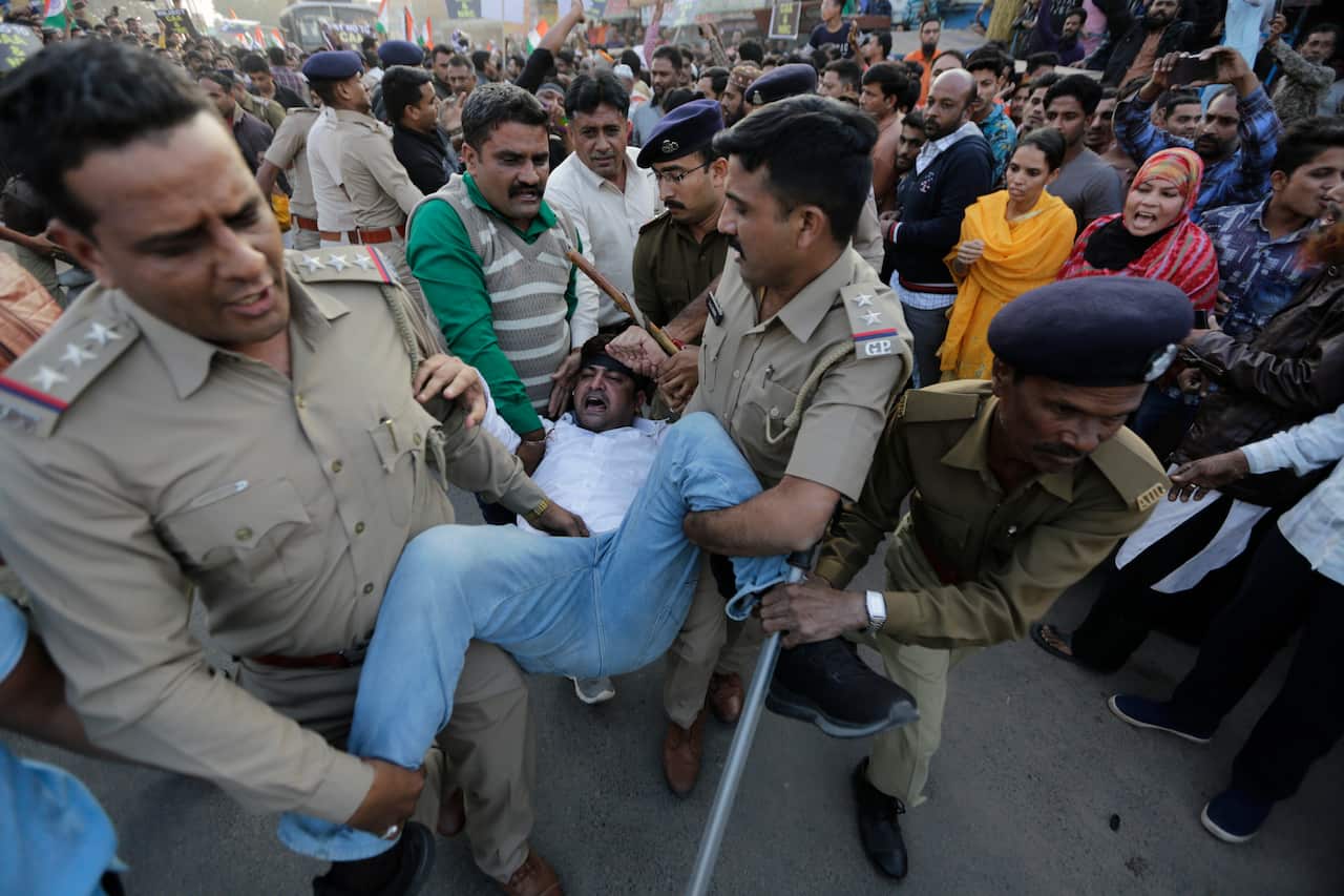 Indian policemen detain a man during a protest against the Citizenship Amendment Act.