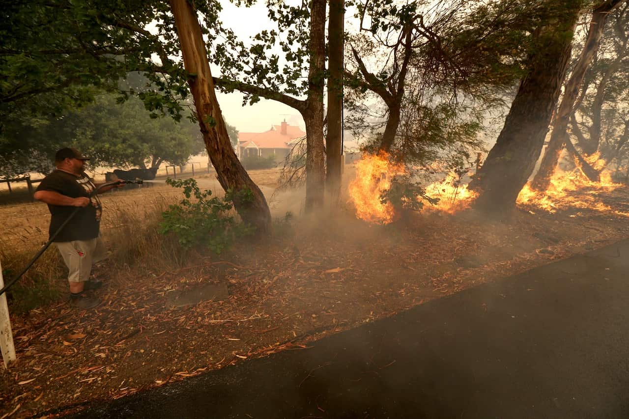 A Woodside resident battles a fire on Friday.