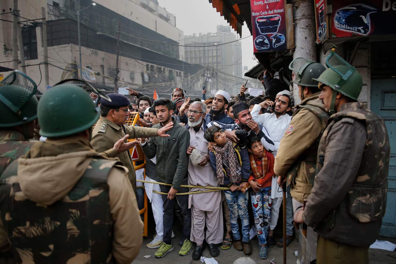 Indian policemen stop protesters at a police barricade in New Delhi.