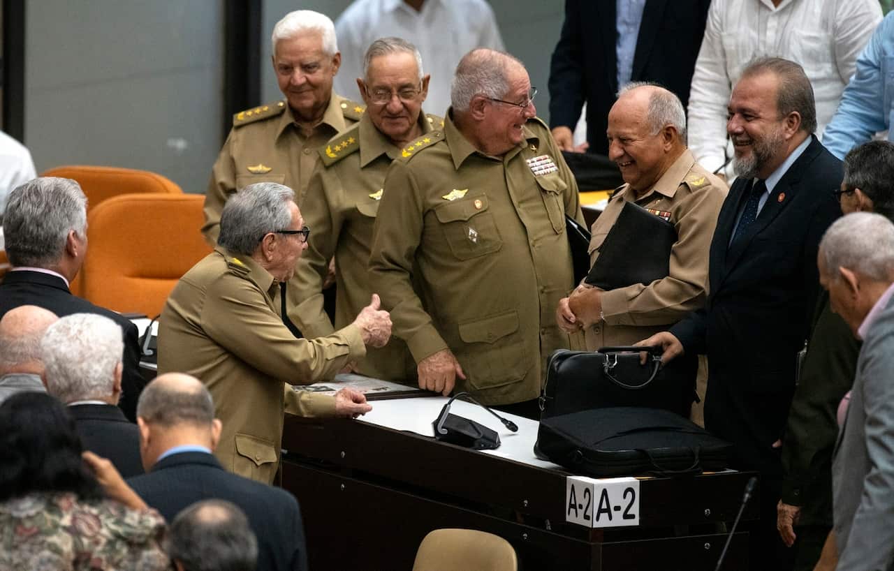 Raul Castro, First Secretary of the Communist Party, talks with the members of the assembly while Cuban Prime Minister Manuel Marrero Cruz, right, looks on.
