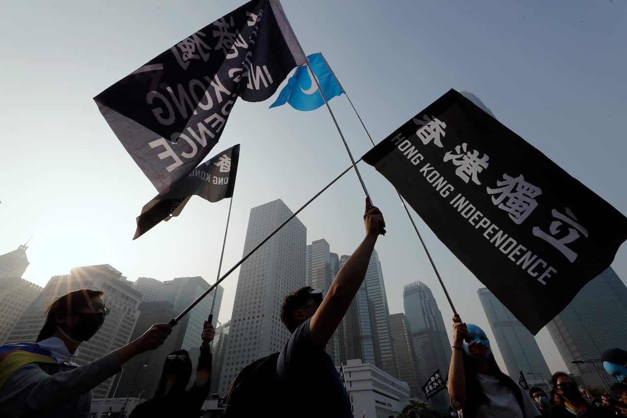 People hold flags during a rally to show support for Uighurs and their fight for human rights.