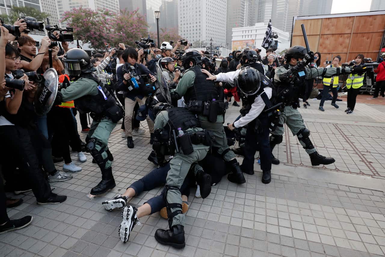 Riot policemen arrest protesters during a rally to show support for Uighurs and their fight for human rights.