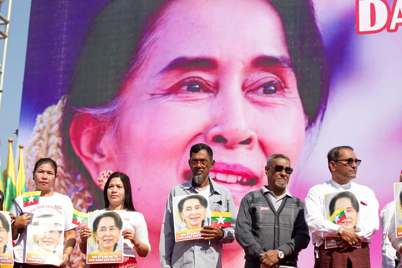 Myanmar Muslims hold portraits of leader Aung San Suu Kyi as they stand and pray in front of City Hall for a rally in Yangon, Myanmar.