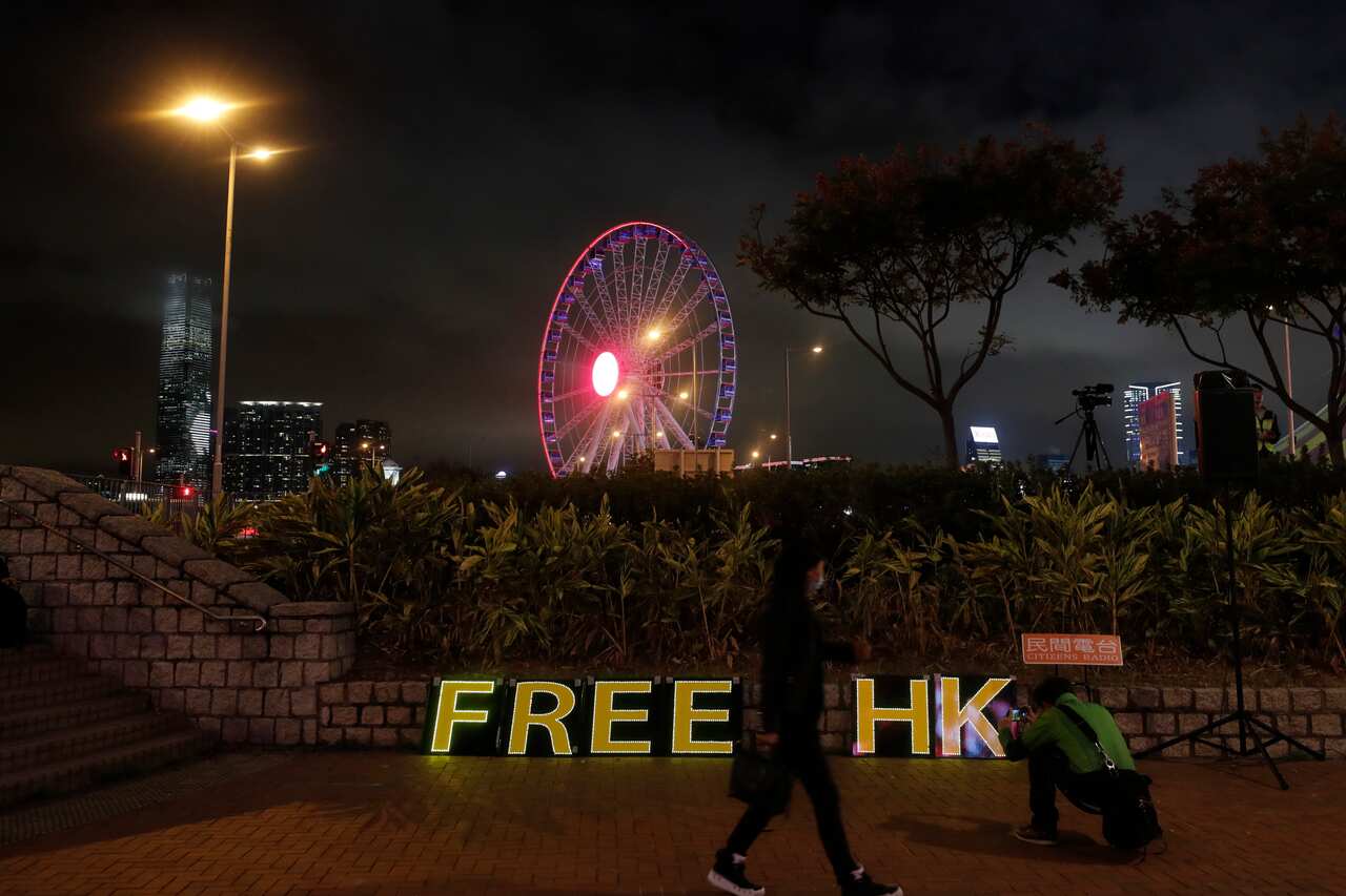 A woman walks near a sign 'Free HK' during a rally in Hong Kong.