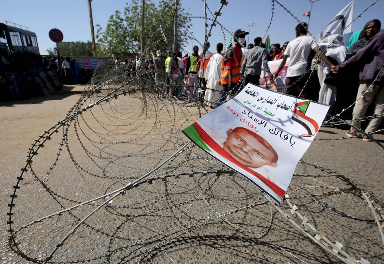 A flyer bearing an image of Ahmed al-Khair, a detained Sudanese demonstrator who died while in custody, hangs on barbed wire.