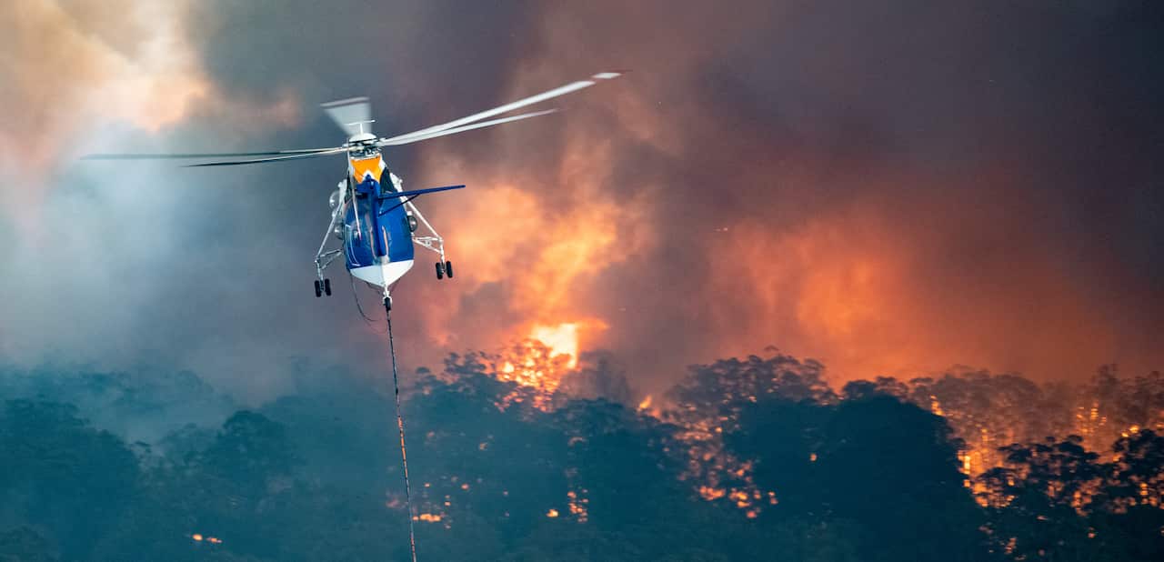 A supplied image obtained on Tuesday, December 31, 2019 showing a firefighting helicopter tackling a bushfire near Bairnsdale in Victoria?s East Gippsland region, Australia. Picture: (AAP IMAGE/State Government of Victoria) NO ARCHIVING