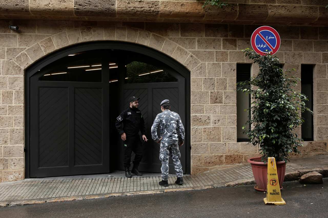A private security guard speaks with a policeman at the residence of former Nissan Chairman Carlos Ghosn.