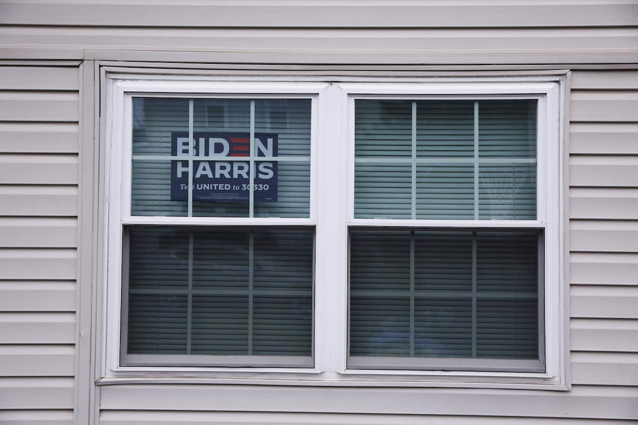 Bonnie Coughlin displays a sign for Democratic Presidential candidate Joe Biden in the window of her home in Gilbertsville, Pennsylvania, U.S., October 26, 2020. REUTERS/Caitlin Ochs