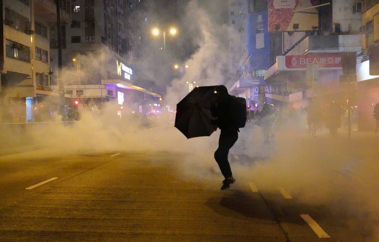 A protester holds an umbrella as police fire tear gas during a demonstration in Hong Kong early on New Year's Day.