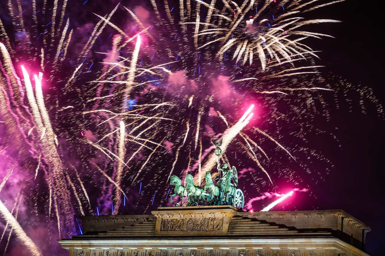 Fireworks light the sky above the Quadriga at the Brandenburg Gate during New Year celebrations in Berlin, Germany.