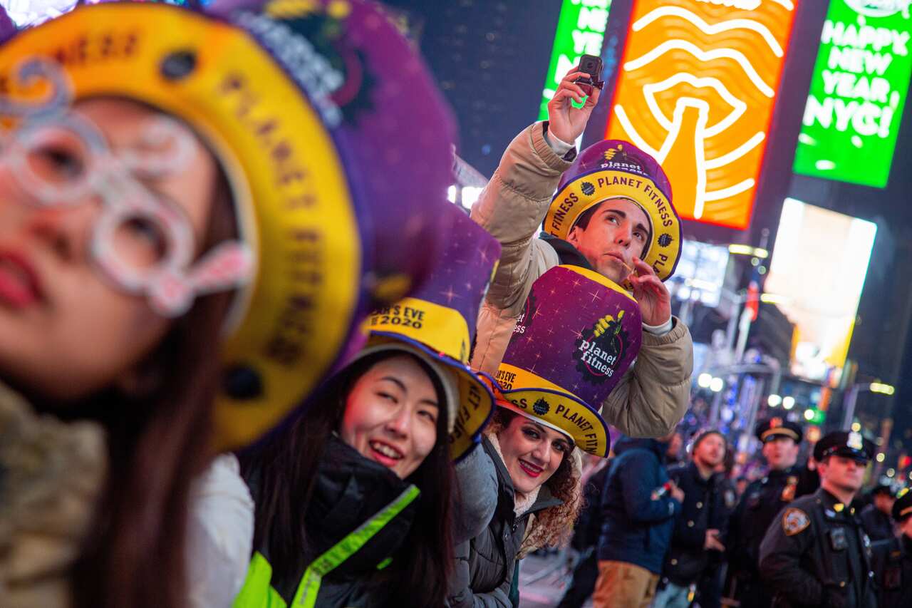 epa08097039 People watch fireworks during New Year's Eve celebrations at Time Square, New York, USA, 31 December 2019.  EPA/ANGEL COLMENARES