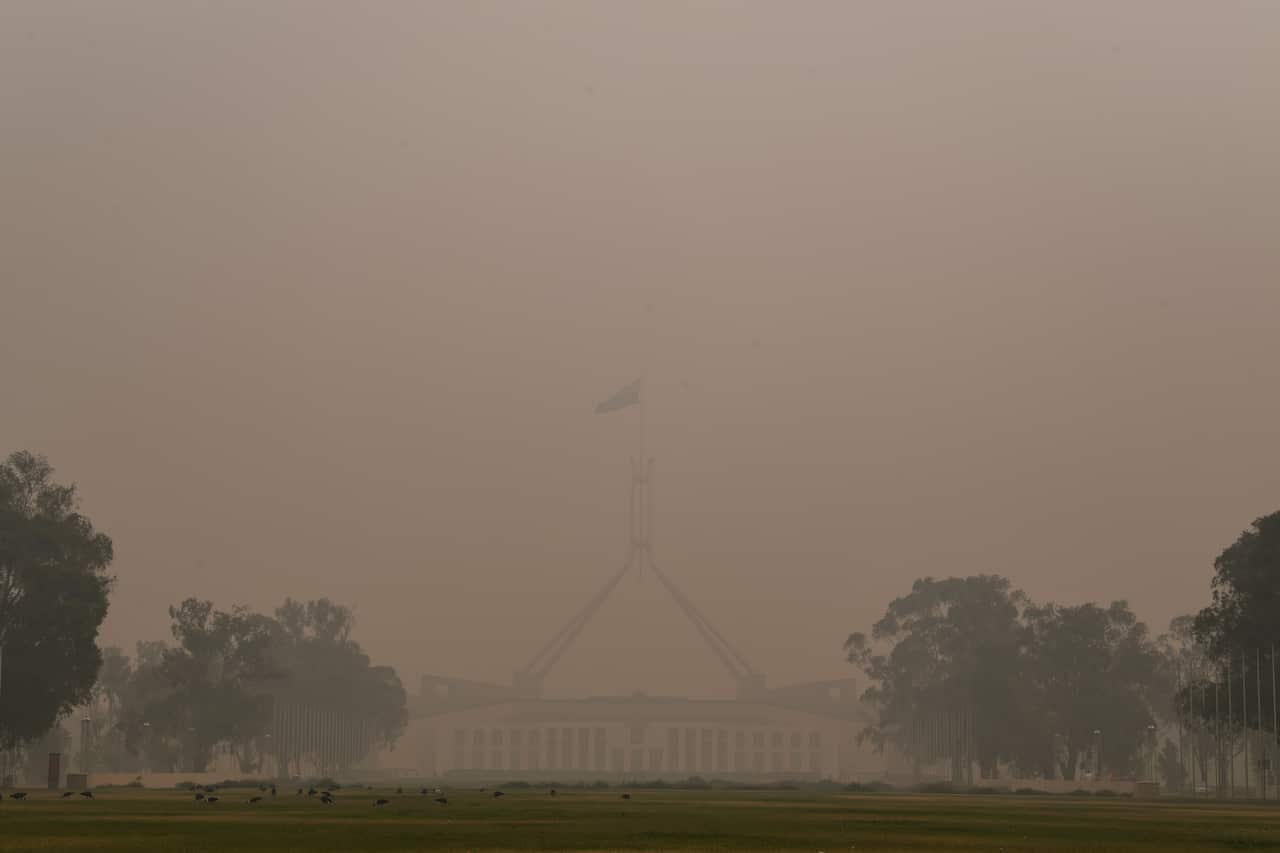 Parliament House is seen through thick smoke haze in Canberra.