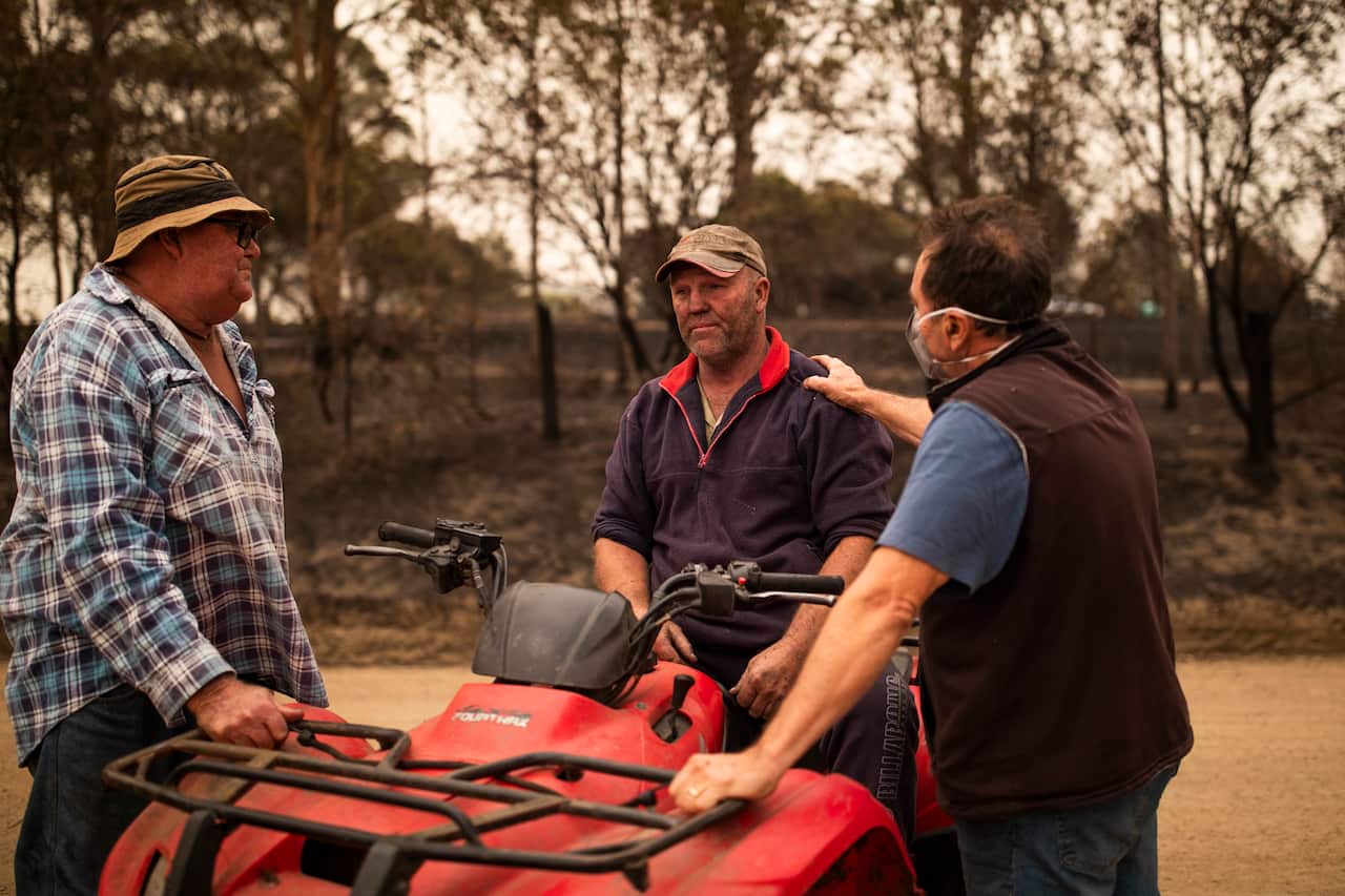 Steve Shipton (centre) is consoled by fellow farmers Bernie Smith (left) and Peter Mercieca in Coolagolite, NSW, Wednesday, 1 January, 2020.