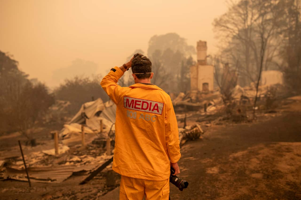 ABC photographer Matt Roberts reacts to seeing his sister's destroyed house in Quaama, NSW.