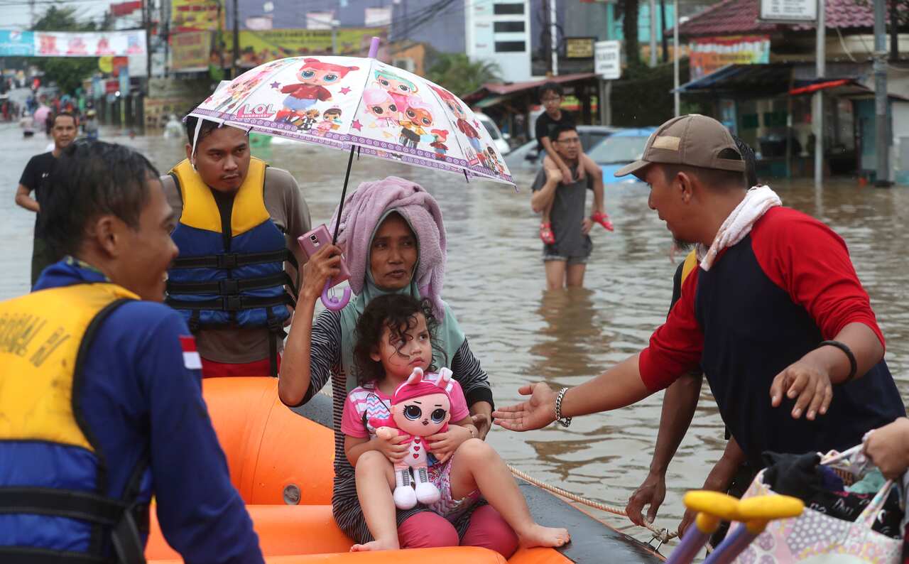 Rescue team talks to a little girls after wade through floodwaters at Jatibening outskirt of Jakarta, Indonesia.