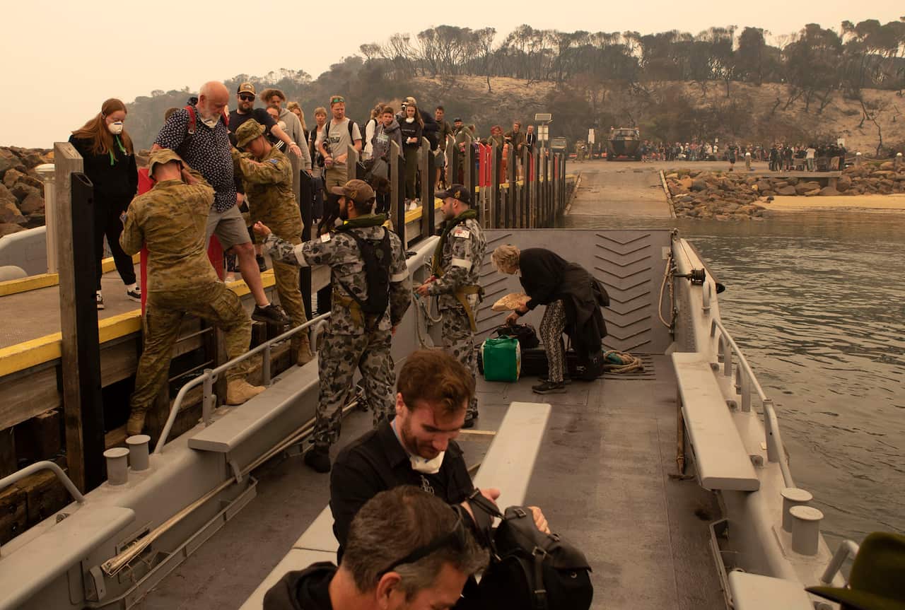 Bushfire evacuees boarding one of HMAS Choules' landing craft at Mallacoota before being ferried out the ship on January 3, 2020.