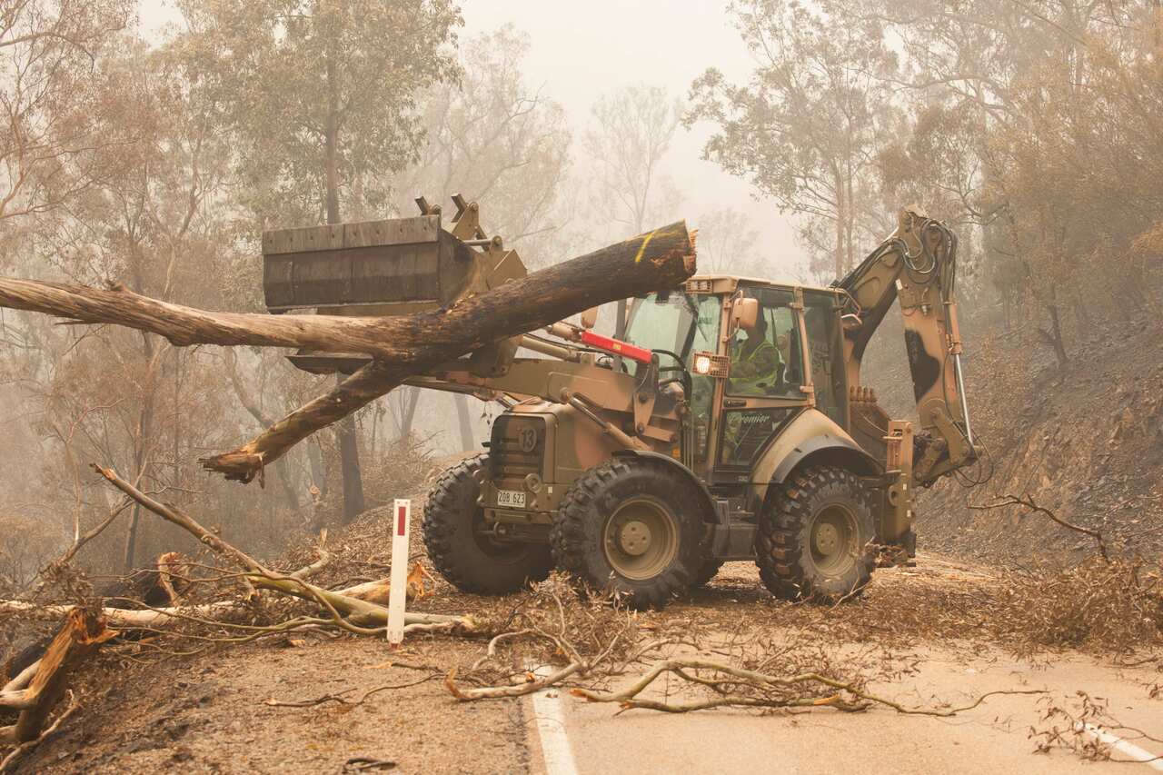 Plant operators Cpl Duncan Keith and Sapper Ian Larner of the 22nd Engineer Regiment use a 434 backhoe to assist staff from Forestry Management Victoria.