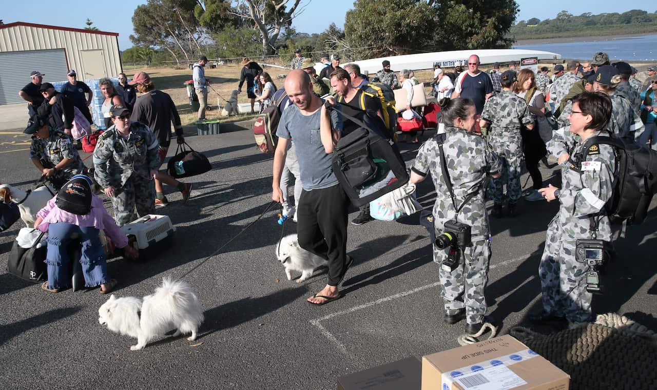 CFA firefighters and 205 evacuees from Mallacoota disembark HMAS Choules.
