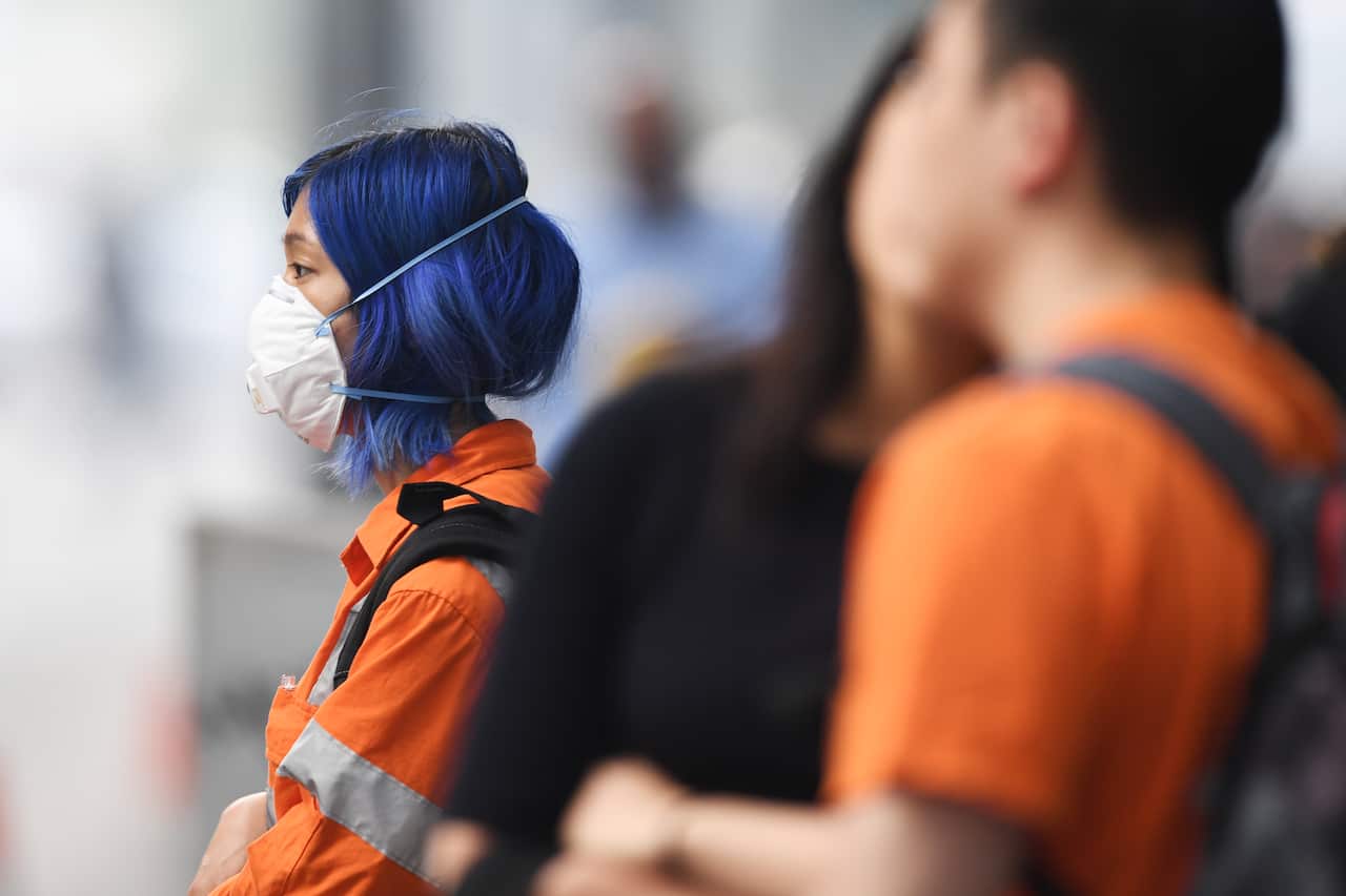 A pedestrian wears a face mask amid smoke haze from bushfires in Melbourne, Tuesday, 14 January, 2020.