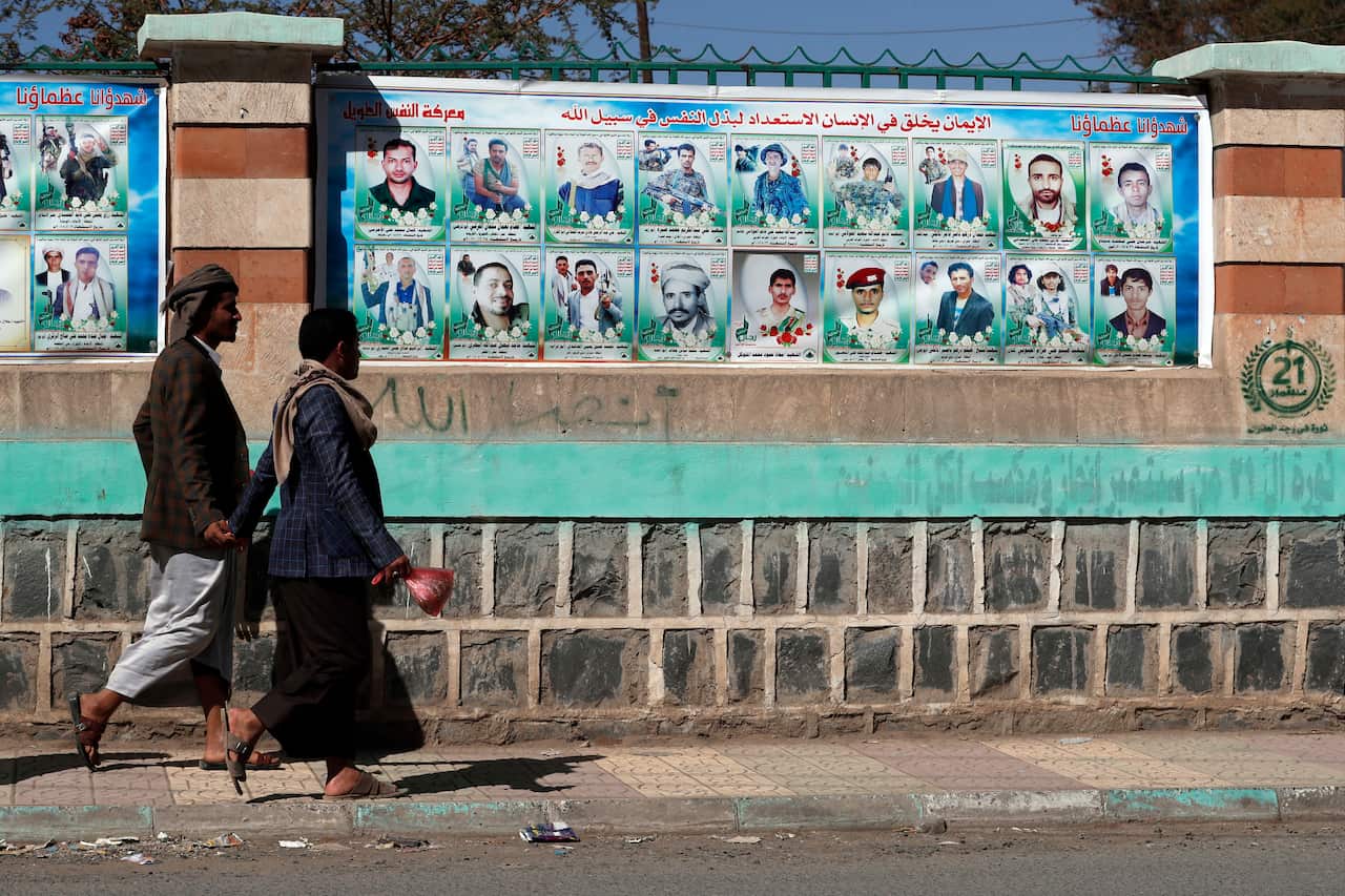 A wall with banners depicting portraits of Houthi fighters killed in Yemen's ongoing conflict.