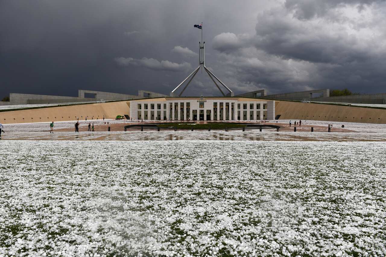 Golf ball-sized hail covers the lawn outside Parliament House in Canberra.