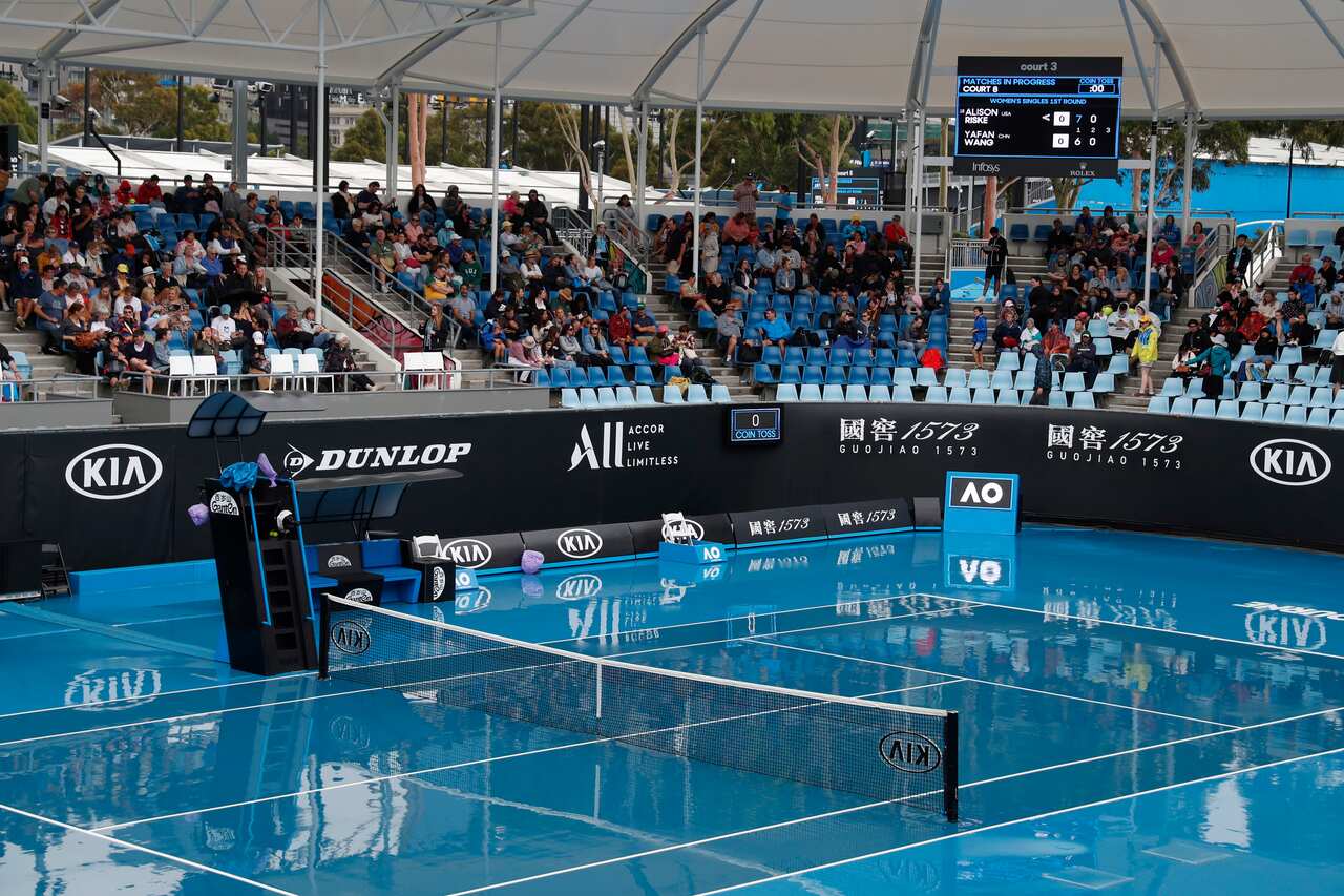 Tennis fans wait for the rain to abate at the Australian Open Grand Slam tennis tournament in Melbourne.