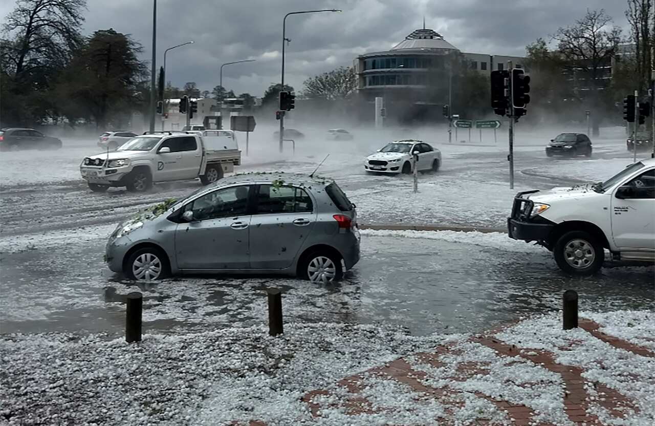 Hail covers vehicles in an intersection in Canberra.