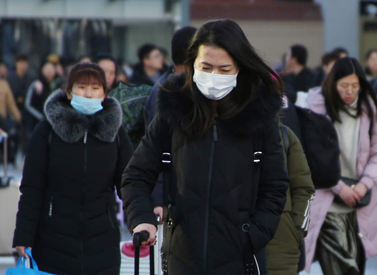 Travellers in Beijing wear face masks to protect themselves from the threat of coronavirus.