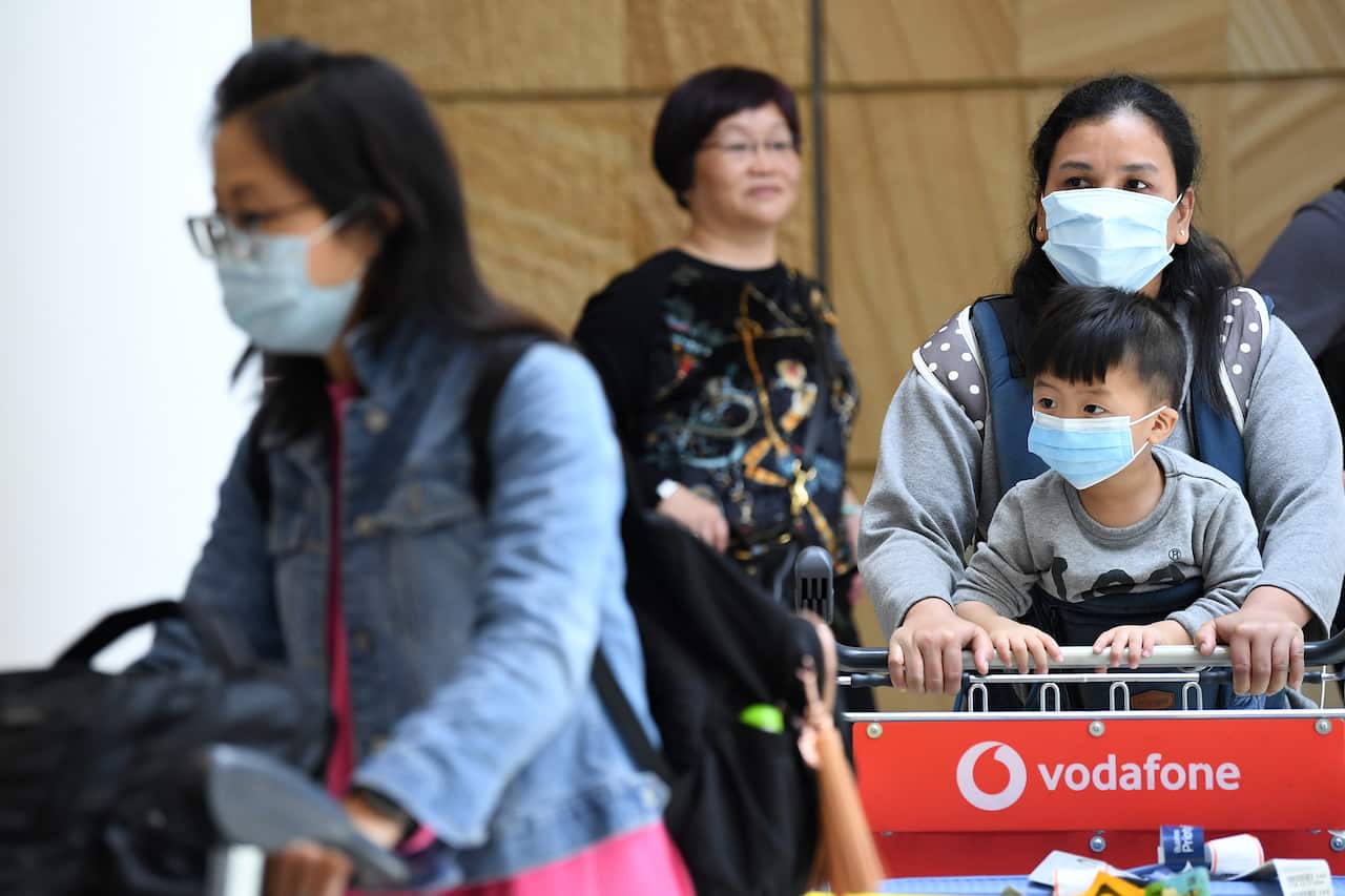 Passengers wearing protective masks arrive at Sydney International Airport.