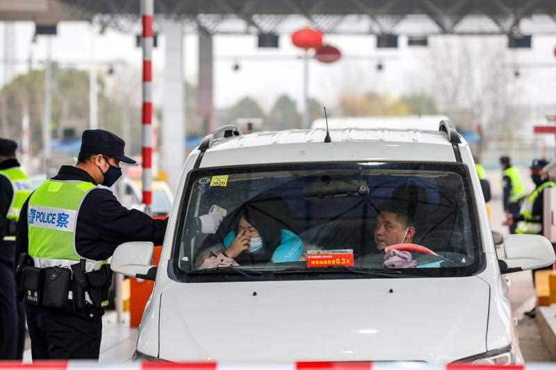 The body temperature of a passenger is checked at an expressway toll gate in Wuhan