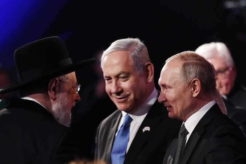 Rabbi Israel Meir Lau, Chairman of the Yad Vashem Council (L) speaks to Israeli Prime Minister Benjamin Netanyahu (C) and Russian President Vladimir Putin (R)