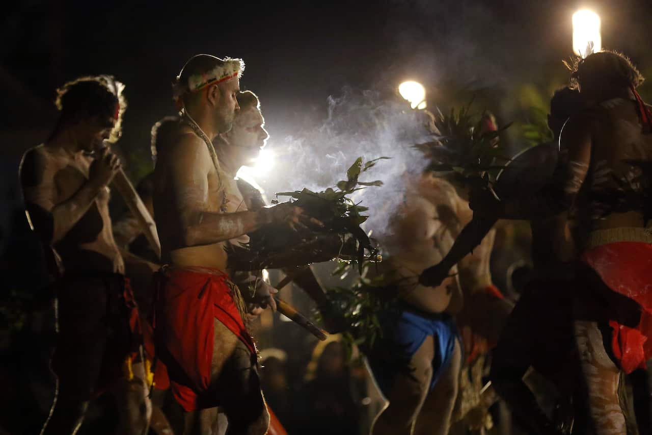 Indigenous dancer perform a smoking ceremony during a vigil on the eve of Australia Day, at Barangaroo in Sydney, Saturday, January 25, 2020. (AAP Image/Steven Saphore) NO ARCHIVING