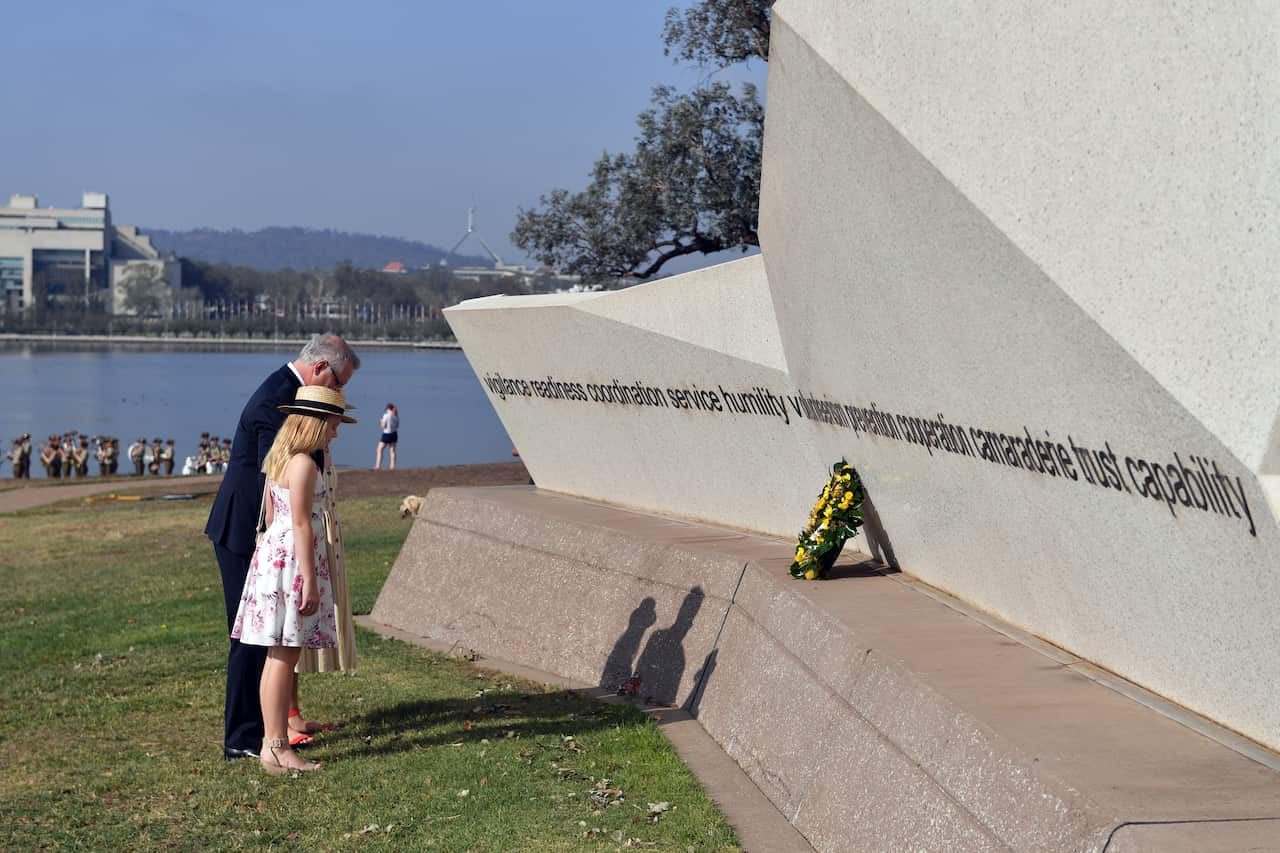 Prime Minister Scott Morrison and daughters Abbey and Lily lay a wreath at the National Emergency Services Memorial on Australia Day.