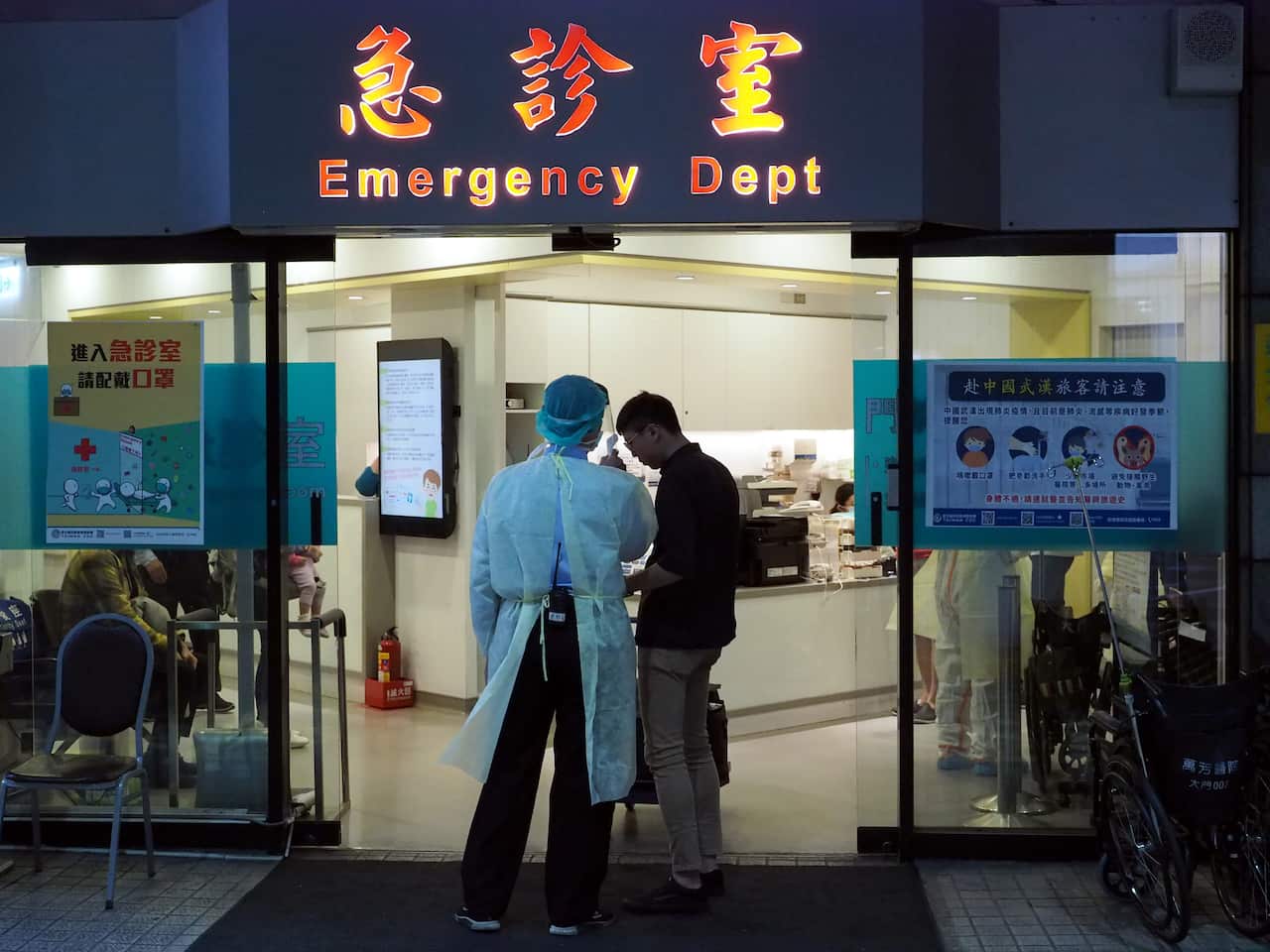A medical staff member (L) waits to check the body temperature of those at risk at a hospital in Taipei, Taiwan.