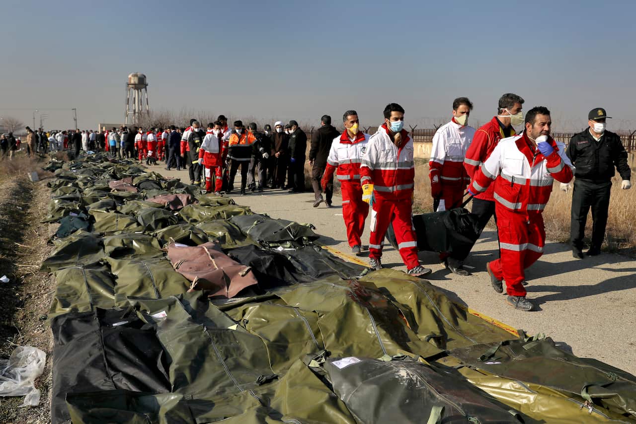 Rescue workers carry the body of a victim of a Ukrainian plane crash in Shahedshahr, southwest of the capital Tehran, Iran. 