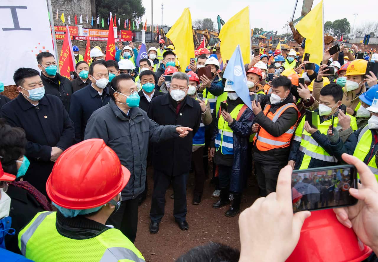 Chinese Premier Li Keqiang speaks with construction workers at the site of makeshift field hospital being built in Wuhan.