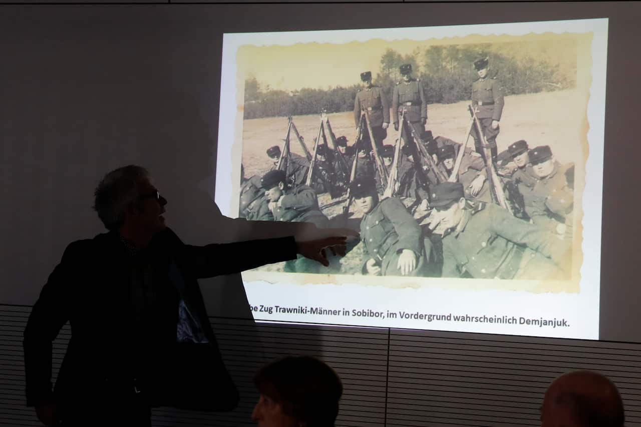 Historian Martin Cueppers points at a man, presumably former security guard John Demjanjuk.