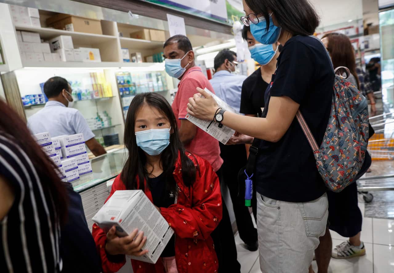 A young girl holds a box of N95 masks at a shopping mall in Singapore.
