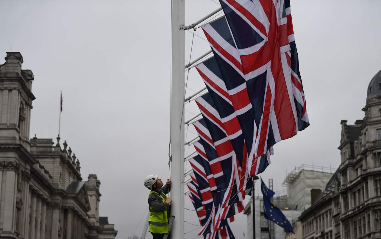 epaselect epa08178581 A man raises Union Flags on Parliament Square in London, Britain, 30 January 2020. After a process that lasted over three years, Britain's withdrawal from the EU is set for midnight CET on 31 January 2020.  EPA/NEIL HALL