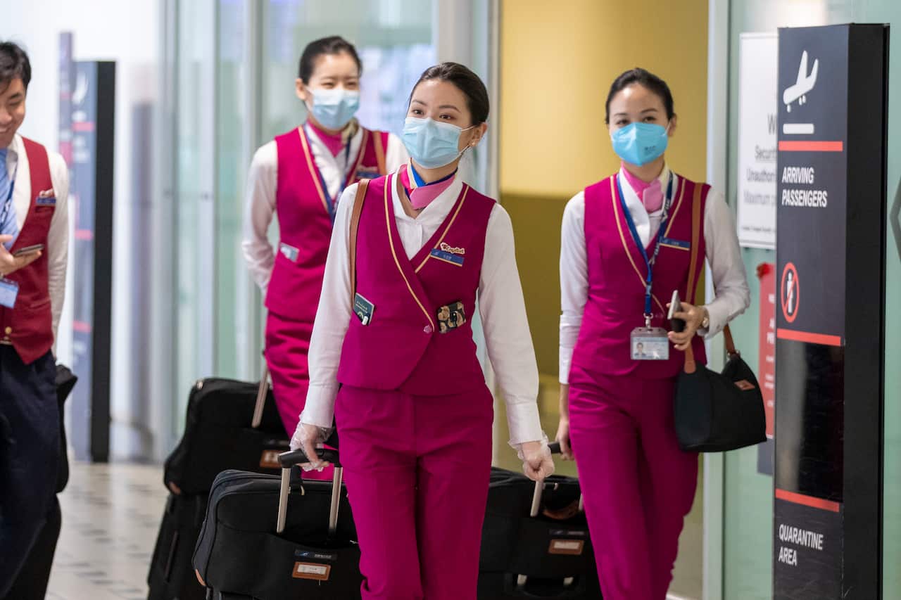 People wearing protective face masks to protect themselves from Coronavirus are seen at Brisbane International Airport.