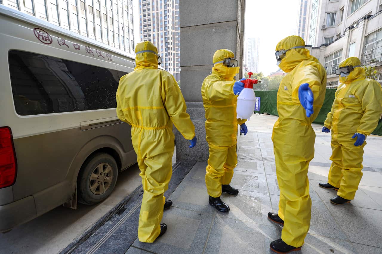 In this photo from January, funeral workers disinfect themselves after handling a virus victim in Wuhan in central China's Hubei Province.