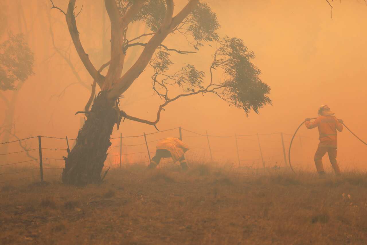 NSW RFS crews extinguish a fire that crossed the Monaro Highway, four kilometres north of Bredbo, Sunday, February 2, 2020.