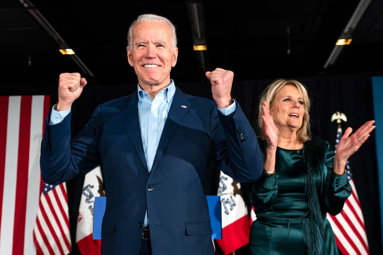 Joe Biden (L), alongside his wife Jill Biden (R), greets supporters during his Iowa caucus night watch party in Des Moines, Iowa, 3 February 2020.