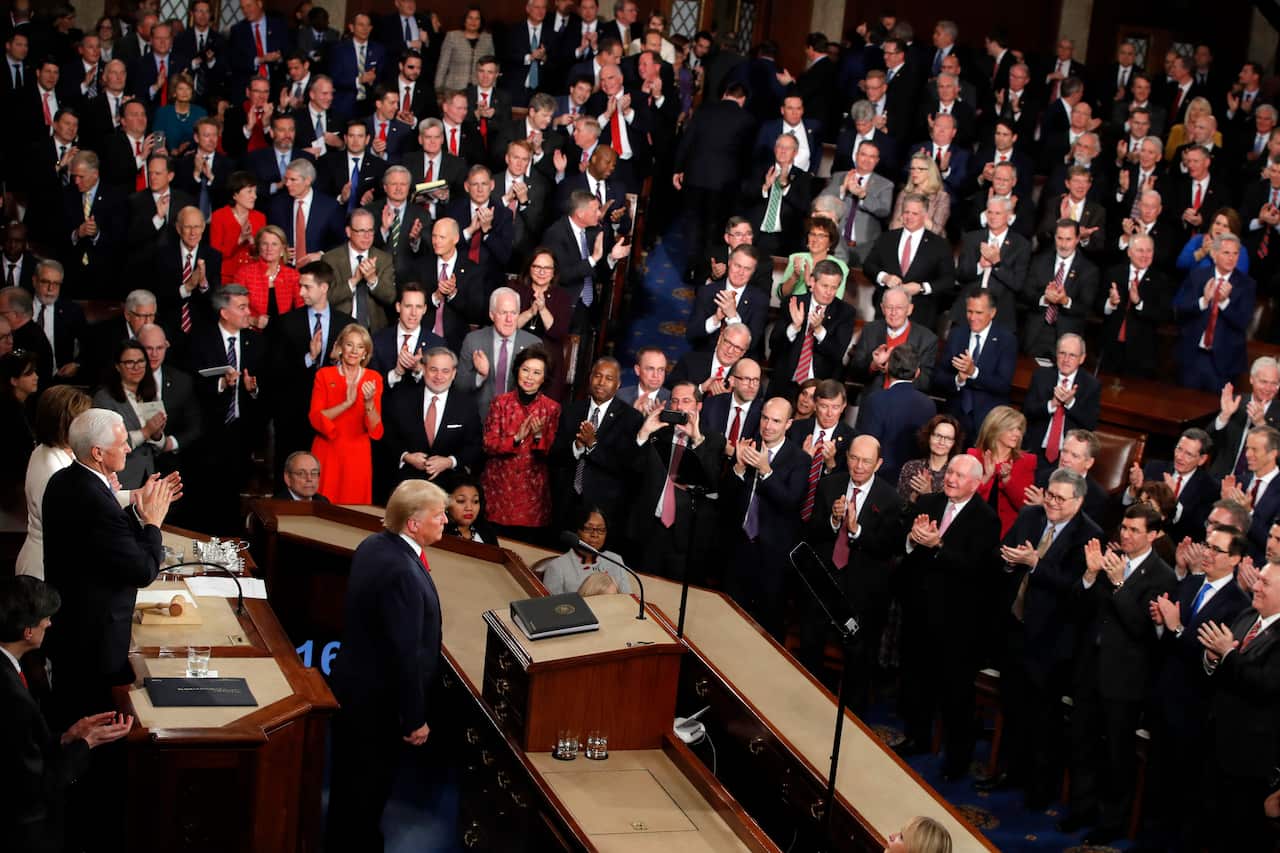 President Donald Trump stands as he finished his State of the Union address to a joint session of Congress on Capitol Hill in Washington, Tuesday, Feb. 4, 2020. (AP Photo/J. Scott Applewhite)